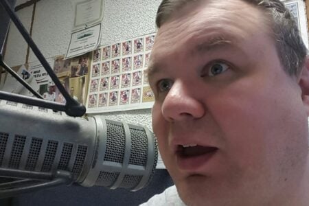WFLR radio personality speaks animatedly into a studio microphone.