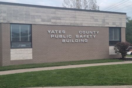 The Yates County Public Safety Building, a brick structure with prominent signage, is seen from outside.