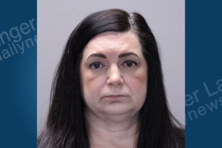 Mugshot of a woman with dark hair and a neutral expression looking directly at the camera.