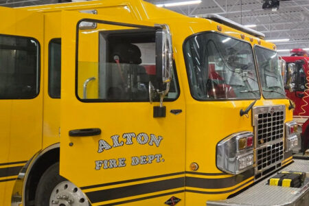 Close-up of a yellow Alton Fire Department fire truck parked inside a fire station.