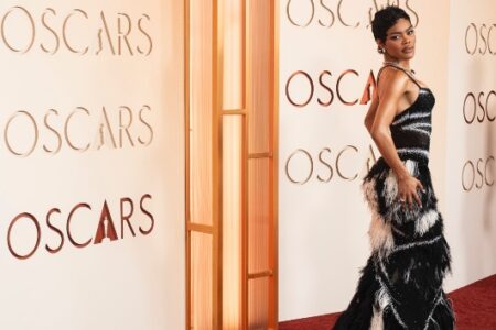 Teyana Taylor on the red carpet at the Oscars, wearing a black and white feathered dress.