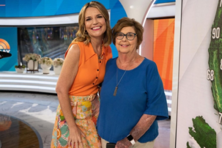 Savannah Guthrie smiles with an older woman in the Today Show studio, with a weather map behind them.