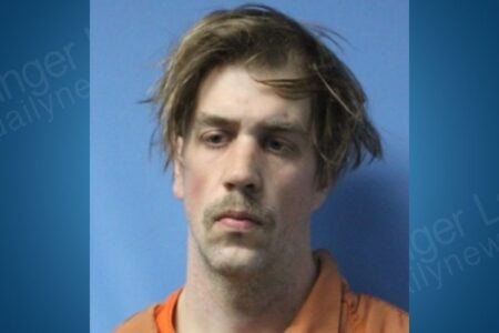 Mugshot of Joseph Cottrell, a man with light brown hair and a mustache, wearing an orange jumpsuit.