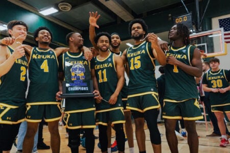 Keuka College men's basketball team celebrates their 2023-24 Empire 8 championship with a trophy on the court.