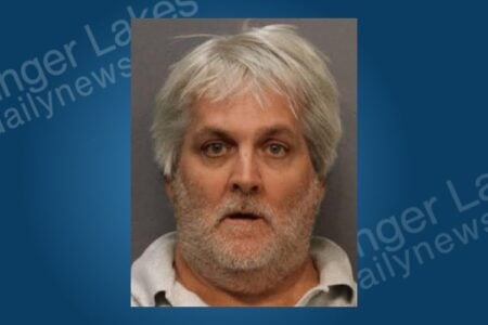 Mugshot of a middle-aged man with gray hair and a beard against a neutral background.
