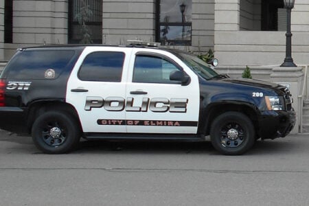 City of Elmira Police SUV parked near a stone building.