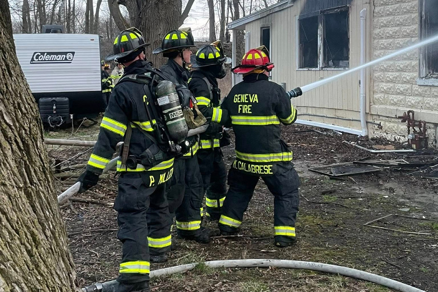 Geneva firefighters spray water on a burning house during a fire scene in the Finger Lakes region.