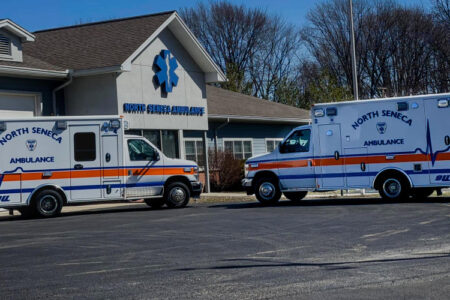 Two North Seneca Ambulance vehicles are parked outside their building on a sunny day.