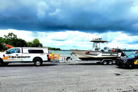 Seneca County Sheriff's vehicles, including a boat trailer, are staged near a Finger Lakes waterway.