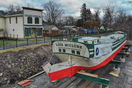 The Lois McClure canal schooner from Burlington, Vermont, dry-docked next to the historic Erie House building.