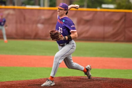 Hobart baseball player #33 in a purple uniform pitches from the mound.