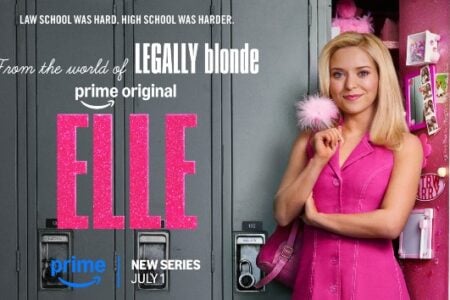 Elle, a blonde woman in a pink dress, smiles, holding a pink fluffy pen, standing by a pink-decorated school locker.