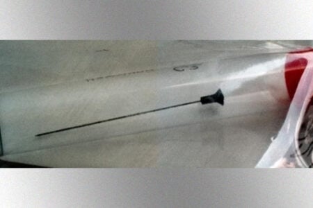 Tranquilizer dart with a black tip sealed inside a clear plastic evidence bag.