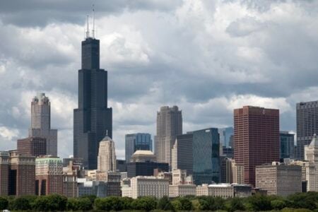 Chicago skyline featuring the tall Willis Tower and other skyscrapers under a cloudy sky.