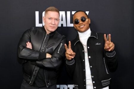Joseph Sikora (black jacket, arms crossed) and Gianni Paolo (sunglasses, white turtleneck, peace signs) pose at a Power event.