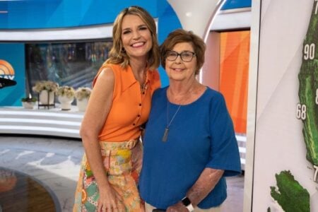 Savannah Guthrie smiles with an older woman on the Today Show set, with a weather map in view.