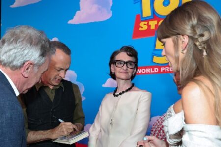 Tom Hanks signs autographs at the Toy Story premiere, while Annie Potts, Taylor Swift, and Conan O'Brien mingle.