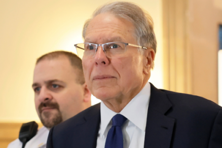 Senior U.S. Circuit Judge Richard Wesley walks through a building, a man in a uniform behind him.