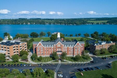 Large brick building on the Hobart and William Smith Colleges campus overlooking Seneca Lake, with a gold dome visible.