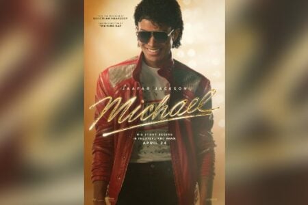Movie poster: Jaafar Jackson as Michael Jackson smiles in a red leather jacket and aviator sunglasses against a golden background.