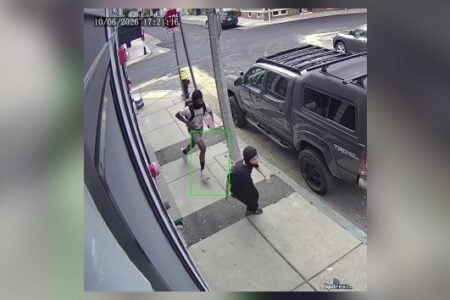 Two masked individuals captured on surveillance camera, one running with a backpack, the other crouching on a sidewalk next to a truck.