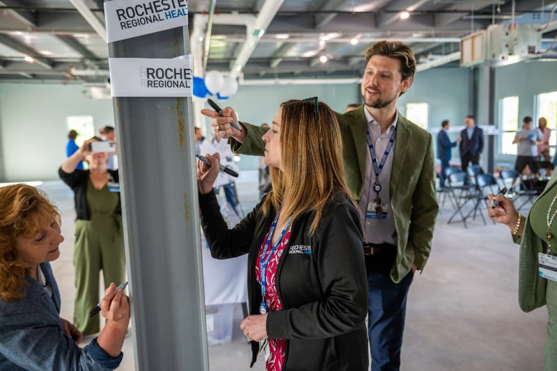 Rochester Regional Health representatives sign a steel beam at a new facility event.