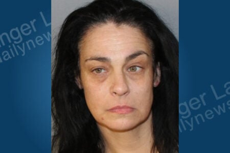 Mugshot of a woman with dark hair and hazel eyes, looking directly at the camera with a neutral expression.