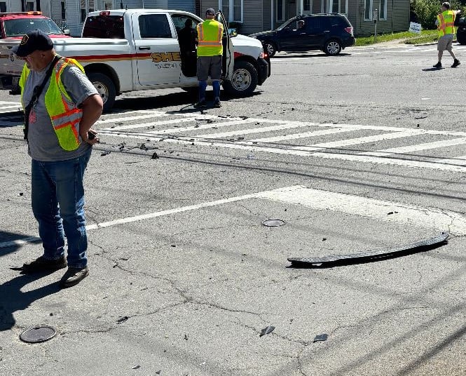 Sheriff's deputies and officials observe debris on a street following an incident.