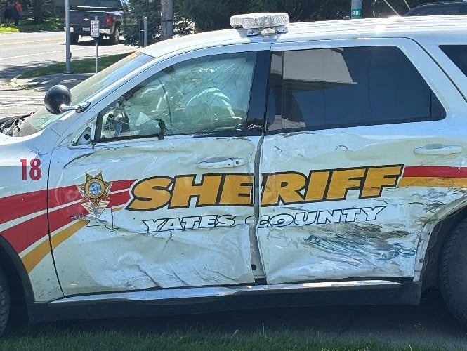 Heavily damaged Yates County Sheriff patrol vehicle after an accident, with severe side dents and a cracked windshield.