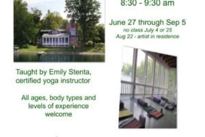 A red and white house at Sunny Point overlooking a lake, with yoga mats laid out on its enclosed porch.