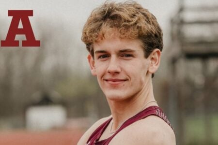 Smiling young male athlete in maroon track uniform, with a red "A" and "TRACK AND FIELD" text.