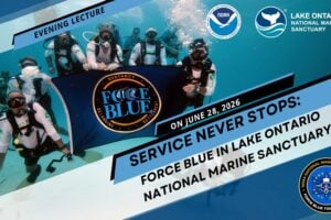 Force Blue scuba divers hold a large blue banner with their logo in clear blue water.