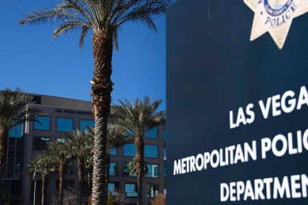 Las Vegas Metropolitan Police Department sign and headquarters building with palm trees under a clear blue sky.