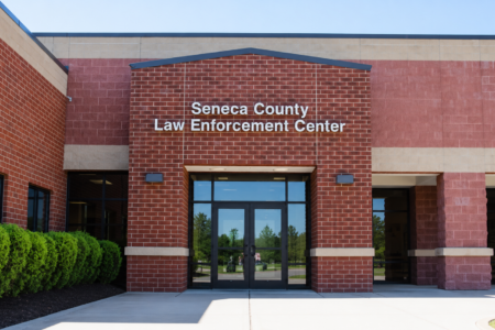 Exterior of the Seneca County Law Enforcement Center, a red brick building with a sign above the glass entrance.