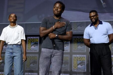 Letitia Wright, Tenoch Huerta, and Winston Duke stand on stage at San Diego Comic-Con.