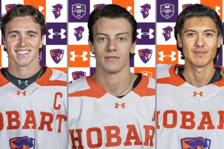 Three Hobart hockey players pose in their white and orange jerseys against a checkered team logo background.