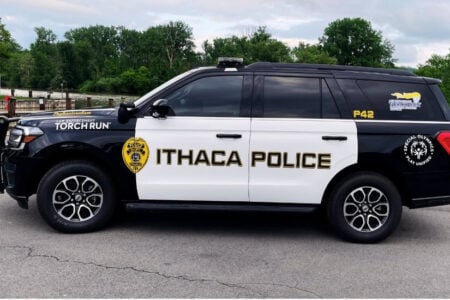 Ithaca Police black & white SUV with Special Olympics Torch Run branding, parked at a waterfront.