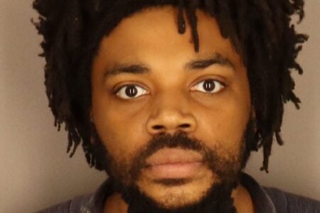 Jamel L. Wright, a Black man with dreadlocks and a beard, faces forward in a Town of Greece Police mugshot.