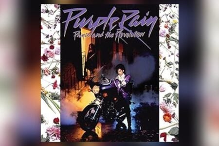 Prince in purple suit leans on his purple motorcycle on the Purple Rain album cover, a smoky street scene.