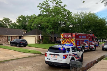 A fire truck and Constable Precinct 4 SUV with flashing lights are parked on a residential street.