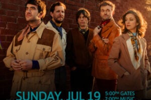 Five members of the band Punch Brothers, four men and one woman, stand in retro attire against a brick wall.