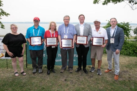 Seven people hold Discover Seneca 2026 Small Business Awards by a Finger Lake.